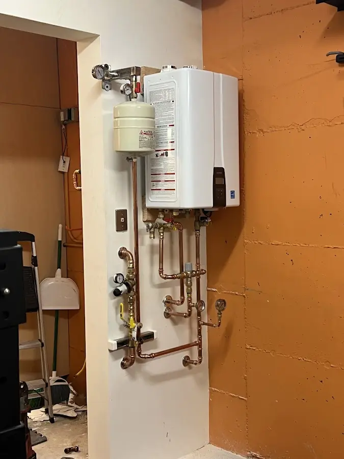 Plumbing technician inspecting water heater connections in Fort Wayne